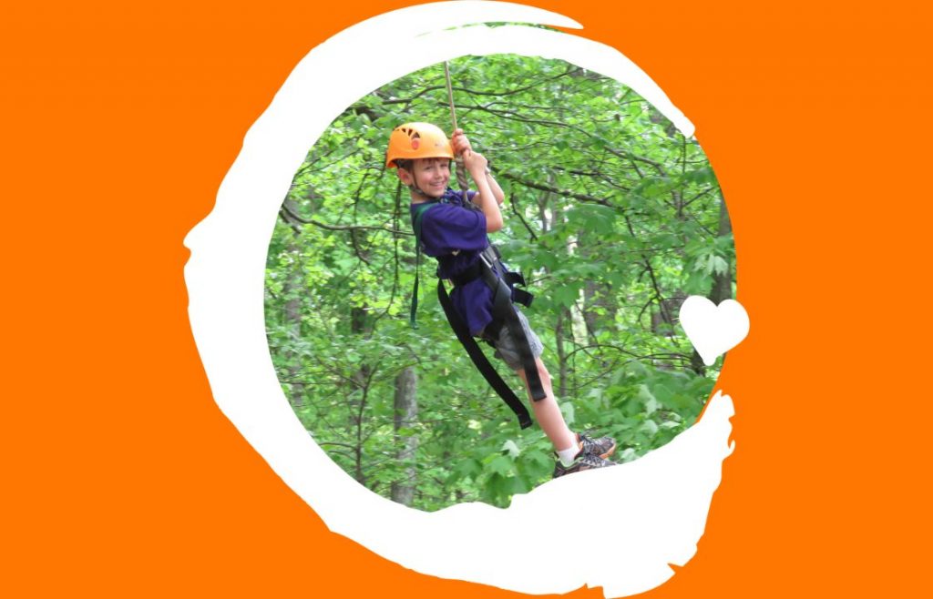 A boy swing on a rope through a forest